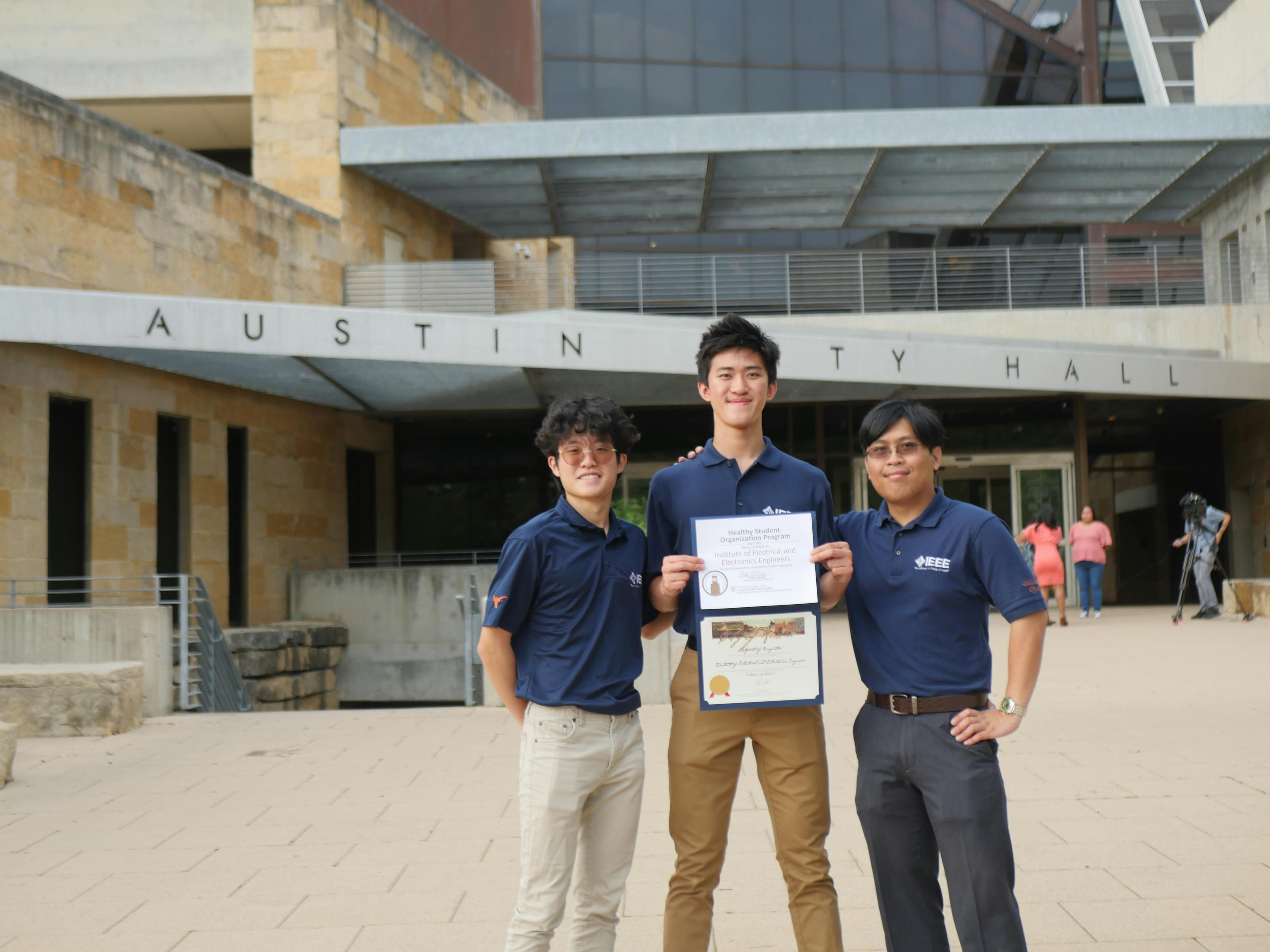 3 IEEE members present an award in front of Austin City Hall