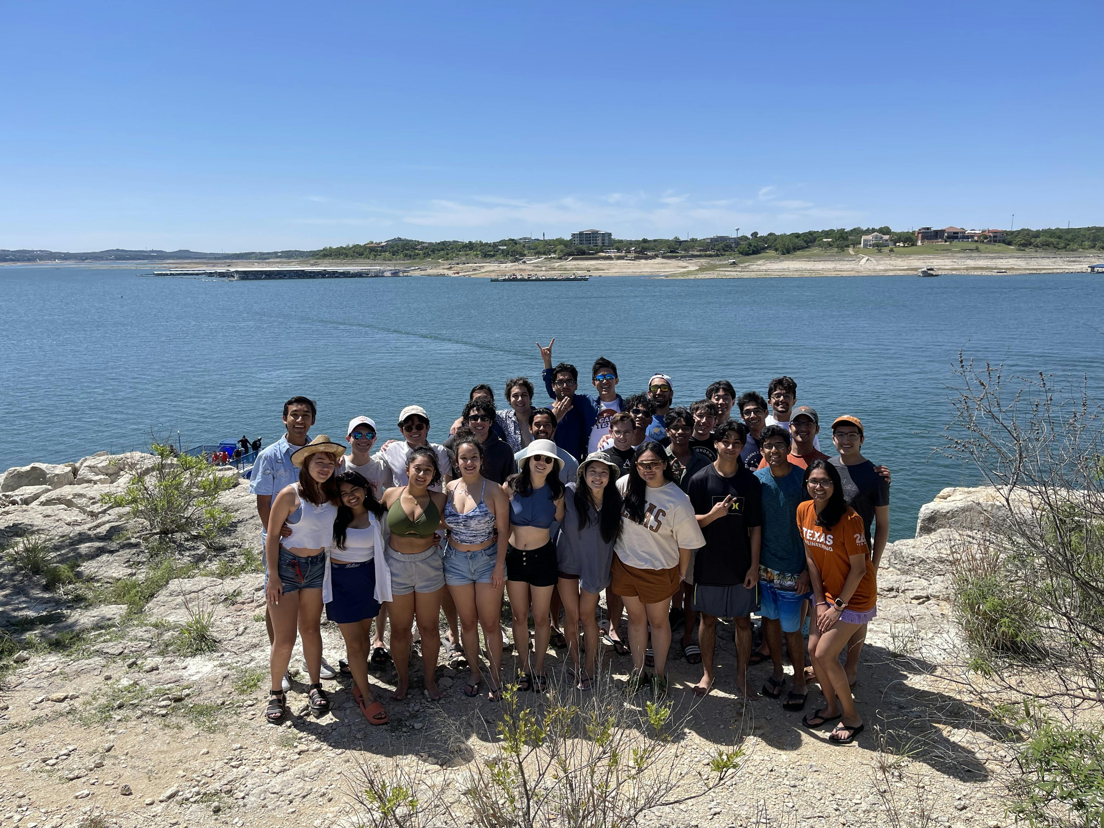 Group photo of IEEE members on rocky hill island in the middle of a lake.
