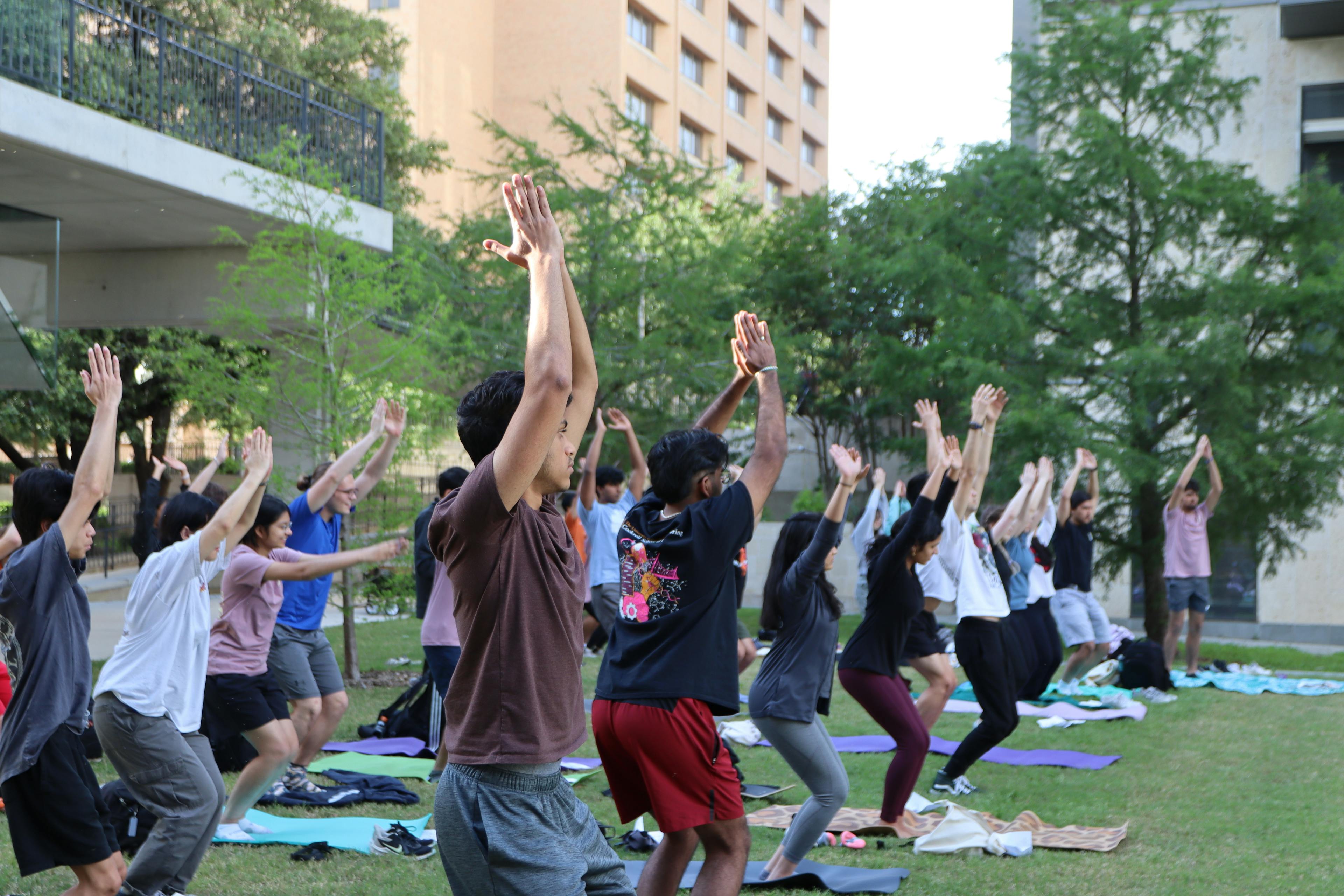 IEEE members reaching over their heads in yoga position